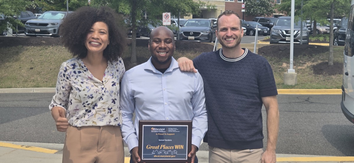 Sennel Gardens team holding a Maryland DHCD Great Places award plaque